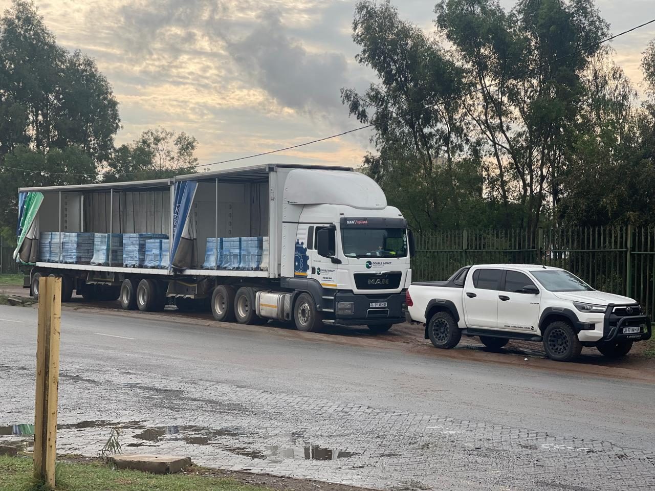 Double Impact Projects truck and branded bakkie on site